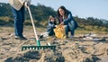 Rake with volunteer women cleaning the beach