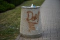 Closeup of random graffiti writings on a bin in a park