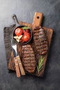 Closeup ready to eat steak Top Blade beef breeds of black Angus with grill tomato, garlic and on a wooden Board. The Royalty Free Stock Photo