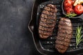 Closeup ready to eat steak Top Blade beef breeds of black Angus with grill tomato, garlic and on a wooden Board. The Royalty Free Stock Photo