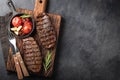 Closeup ready to eat steak Top Blade beef breeds of black Angus with grill tomato, garlic and on a wooden Board. The