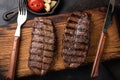 Closeup ready to eat steak Top Blade beef breeds of black Angus with grill tomato, garlic and on a wooden Board. The Royalty Free Stock Photo