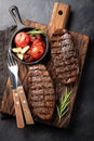 Closeup ready to eat steak Top Blade beef breeds of black Angus with grill tomato, garlic and on a wooden Board. The finished dish Royalty Free Stock Photo