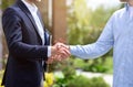 Closeup of real estate agent and his client shaking hands near new house Royalty Free Stock Photo