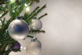 Closeup of real spruce Christmas tree with silver and white ornaments and lights
