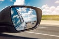 Closeup of rear back car mirror with beautiful landscape midday view of Toronto city highway street road.