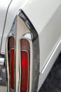 Closeup of a rear chrome lantern in the back of an antique vintage white car. Royalty Free Stock Photo