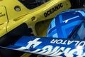 Closeup of a rear spoiler of blue and yellow racecars standing next to each other