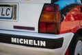 Closeup of the rear view of a Lancia Delta HF covered in a sticker Michelin parked on the street