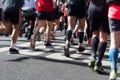 Closeup rear view on marathon runners legs and feet with motion