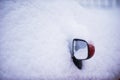 Rear view mirror covered with snow.