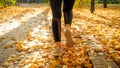 Closeup rear view photo of young woman in sportswear running and training in autumn park