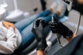 Closeup rear view of unrecognizable female dentist in gloves change drill into tool for treating caries on teeth. Close Royalty Free Stock Photo