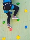 Closeup rear view young woman climbing wall sport safety . Challenge concept