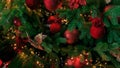 Closeup of red bauble hanging from decorated Christmas tree. Christmas, holidays and seasonal greetings concepts. copy space Royalty Free Stock Photo