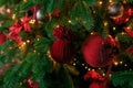 Closeup of red bauble hanging from decorated Christmas tree. Christmas, holidays and seasonal greetings concepts. copy space Royalty Free Stock Photo