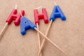 Closeup of red and blue letter candles on sticks that spells out HAHA