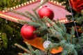 Closeup of Red Christmas balls and garland on a branches of natural New Year tree on festive decorated city fair outdoors at Royalty Free Stock Photo