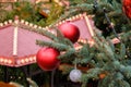 Closeup of Red Christmas balls and garland on a branches of natural New Year tree on festive decorated city fair outdoors at Royalty Free Stock Photo