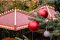 Closeup of Red Christmas balls and garland on a branches of natural New Year tree on festive decorated city market outdoors at Royalty Free Stock Photo