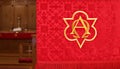 Closeup of red church banner with blurry altar in behind