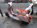 Closeup of a red classic Piaggio Vespa scooter on the street