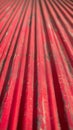 Closeup of a red corrugated metal sheet with weathered texture Royalty Free Stock Photo