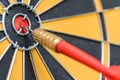 Closeup red dart arrow hitting in target bullseye of dartboard Royalty Free Stock Photo