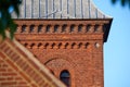 Closeup of a red face brick church steeple against a blue sky. Tall infrastructure and tower used to symbolise faith and Royalty Free Stock Photo