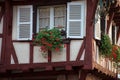 red geraniums at he window of a medieval house facade Royalty Free Stock Photo