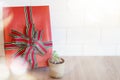 Closeup of red gift box with small tree pot on wood table and white wall. Can use for Happy new year, Merry Christmas, Happy Royalty Free Stock Photo