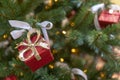 Closeup of red gift boxes and mini lights on the decorated Christmas tree Royalty Free Stock Photo
