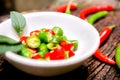 Closeup Red and green chili with chili sliced in the white small bowl on wooden table Royalty Free Stock Photo