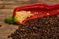 Closeup Red hot chili peppers and black pepper whole in wooden spoon on old wooden background Royalty Free Stock Photo