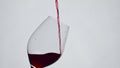 Closeup red liquid filling wineglass slow motion. Wine splashing inside goblet