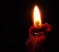 Closeup of red lit candle isolated on dark red background, fire, flame Royalty Free Stock Photo