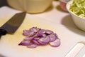 Closeup red onion slice and knife on cutting board Royalty Free Stock Photo