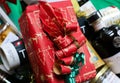 Closeup of red package box wrapped in red Christmas paper in gift hamper basket with whole food products Royalty Free Stock Photo