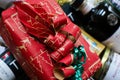 Closeup of red package box wrapped in red Christmas paper in gift hamper basket with whole food products Royalty Free Stock Photo