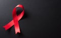 Closeup red ribbon HIV, world AIDS day awareness ribbon on black background. Healthcare and medicine concept Royalty Free Stock Photo