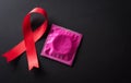 Closeup red ribbon HIV, world AIDS day awareness ribbon on black background. Healthcare and medicine concept Royalty Free Stock Photo