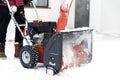 Man using red snowblower machine outdoor. Removing snow near house from yard Royalty Free Stock Photo