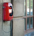 Red street phone on a blurred background of a stone wall of an old house in St. Petersburg