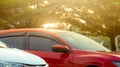 Closeup red SUV car parked at outdoor car parking area of shopping mall or office. Luxury car parked near green tree at car Royalty Free Stock Photo