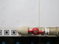 Closeup of red valve which join plastic and metallic pipes