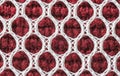 Closeup of red and white fabric showing a regular pattern