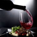 Closeup of red wine pouring into a glass with cheese and meat Royalty Free Stock Photo
