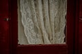 Closeup of the red wooden window frame and lace curtains Royalty Free Stock Photo