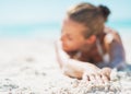 Closeup on relaxed young woman in swimsuit laying on sandy beach Royalty Free Stock Photo