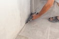 Closeup of repairman hand plastering a wall with putty knife or spatula.